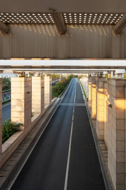Şehirdeki üst geçidin altında beton yapı ve asfalt yol alanı
