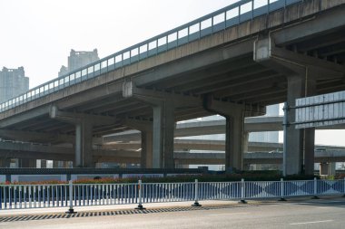 Şehirdeki üst geçidin altında beton yapı ve asfalt yol alanı