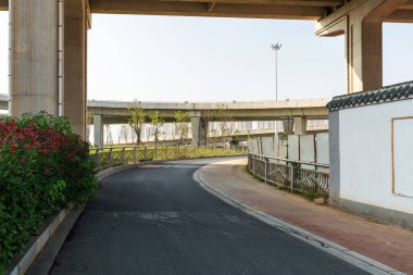 Şehirdeki üst geçidin altında beton yapı ve asfalt yol alanı