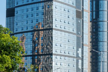 Cam ofis binasının güzel arka planı, açık pencerelerdeki bulutları yansıtıyor.