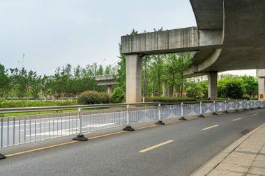 Şehirdeki üst geçidin altında beton yapı ve asfalt yol alanı