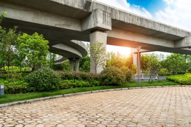Şehirdeki üst geçidin altında beton yapı ve asfalt yol alanı