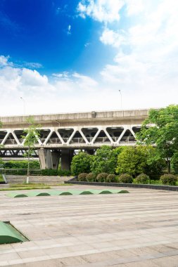 Şehirdeki üst geçidin altında beton yapı ve asfalt yol alanı