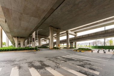 Şehirdeki üst geçidin altında beton yapı ve asfalt yol alanı