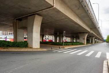 Şehirdeki üst geçidin altında beton yapı ve asfalt yol alanı