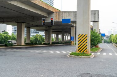 Şehirdeki üst geçidin altında beton yapı ve asfalt yol alanı