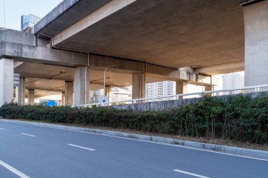 Şehirdeki üst geçidin altında beton yapı ve asfalt yol alanı