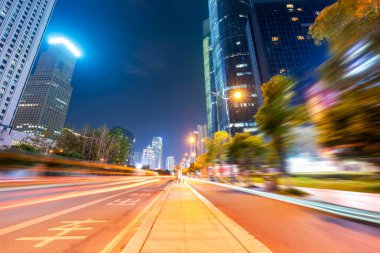 Şangay 'daki modern binanın arka planındaki ışık yolları.. 