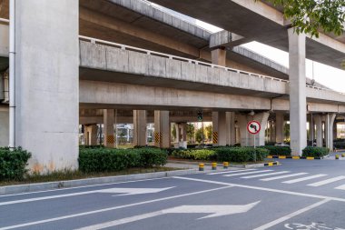 Şehirdeki üst geçidin altında beton yapı ve asfalt yol alanı