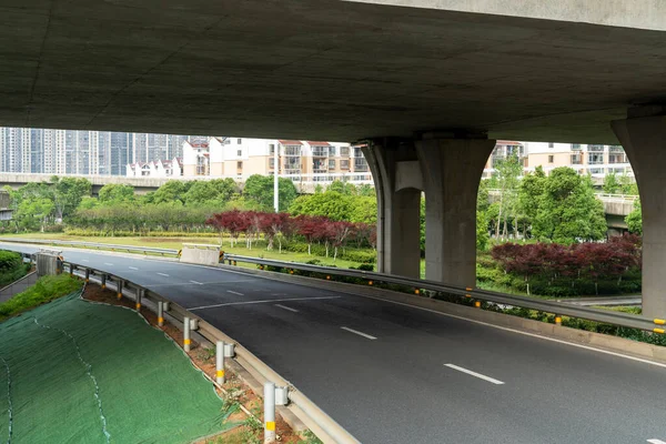 Concrete structure and asphalt road space under the overpass in the city