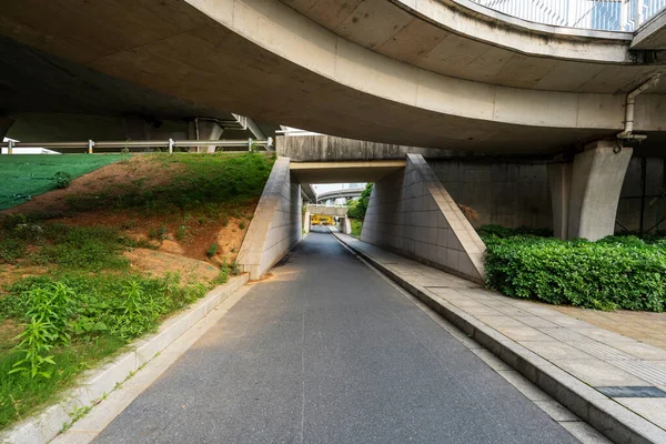 Concrete structure and asphalt road space under the overpass in the city