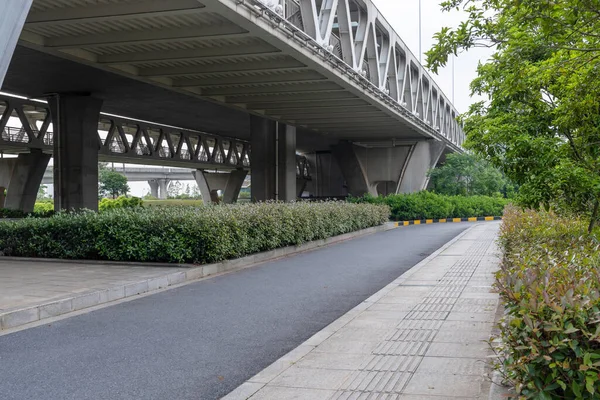 Concrete structure and asphalt road space under the overpass in the city