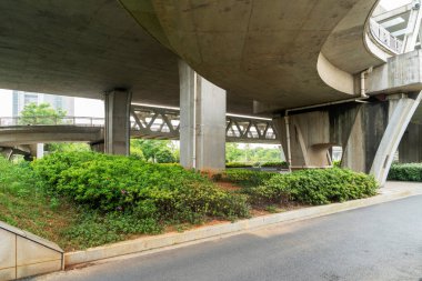 Şehirdeki üst geçidin altında beton yapı ve asfalt yol alanı