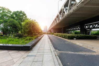 Şehirdeki üst geçidin altında beton yapı ve asfalt yol alanı