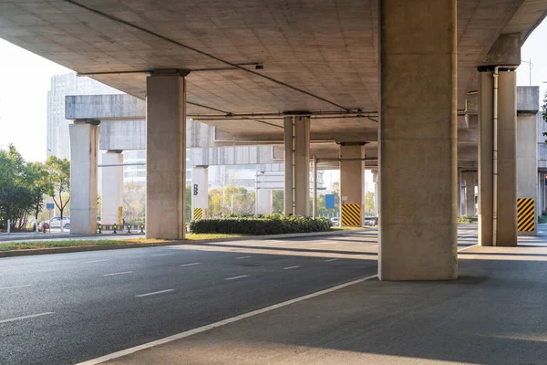 Concrete structure and asphalt road space under the overpass in the city