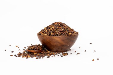Indigofera or indigo seeds in wooden bowl isolated on white background