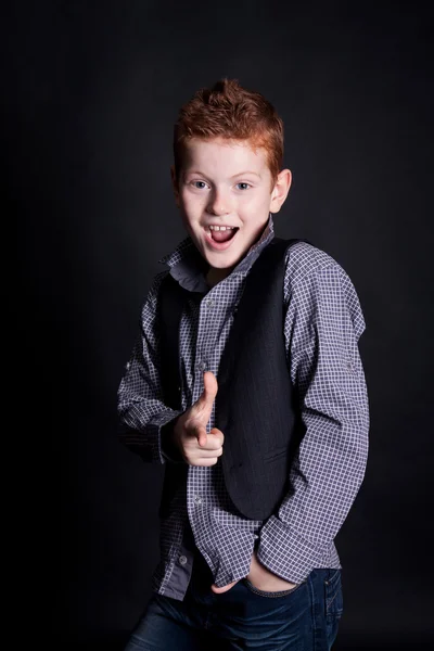 Cheerful red-haired boy on a black background — ストック写真
