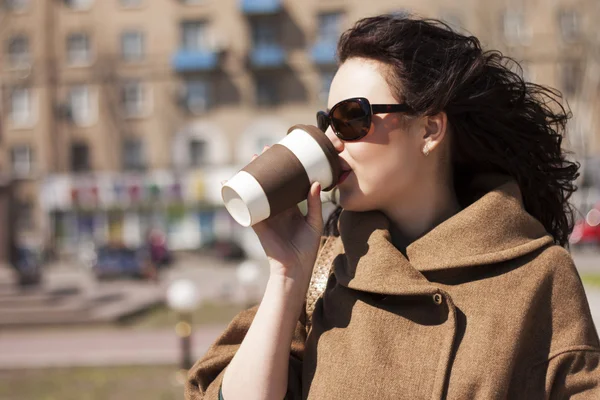 Mädchen mit einem Kaffee auf der Straße. Stockfoto