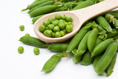 Beyaz arkaplanda yeşil bezelyeler.