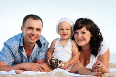 Sahilde bir kızı hamile mutlu aile.