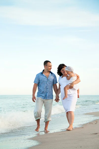 Happy pregnant family with a daughter on the beach. — Stock Photo, Image