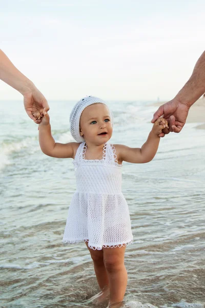 Zwangere en gelukkige familie met een dochter op het strand. — Stockfoto