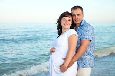 gebelik. seven çift sahilde genç.