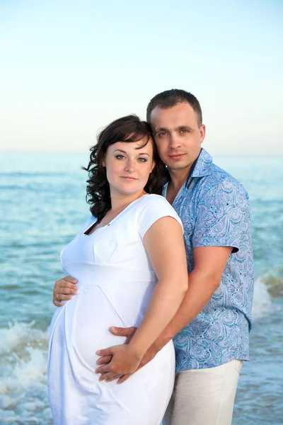 Zwangerschap. jonge liefdevol paar op het strand. — Stockfoto