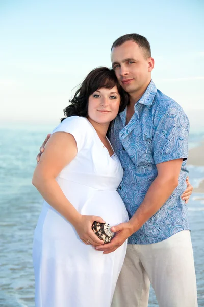 Zwangerschap. jonge liefdevol paar op het strand. — Stockfoto