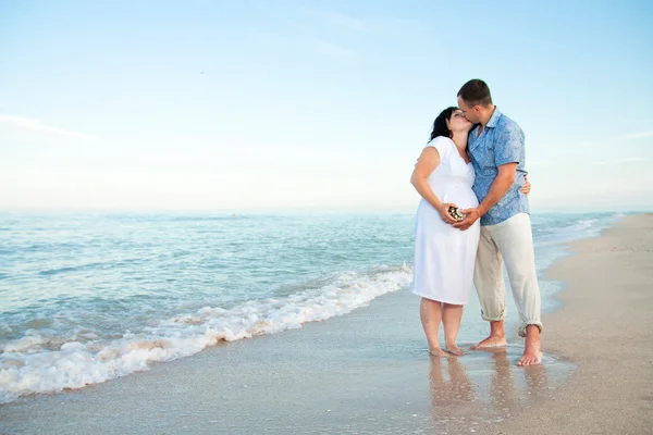 Zwangerschap. jonge liefdevol paar op het strand. — Stockfoto