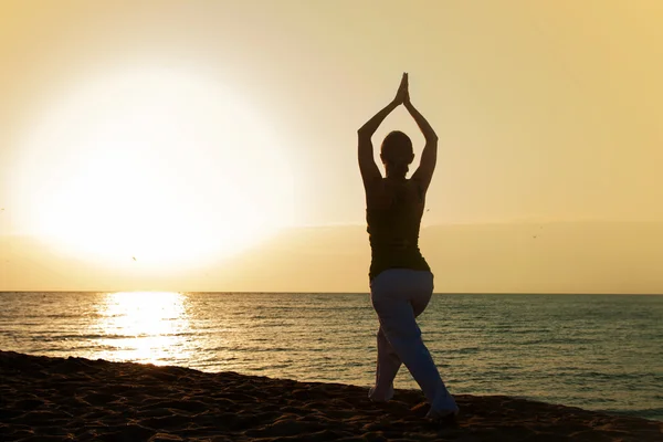 Yoga na praia ao nascer do sol . — Fotografia de Stock