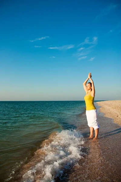 Yoga na praia ao nascer do sol . — Fotografia de Stock