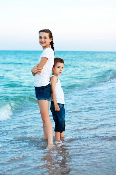 Sister and brother on the evening beach. Happy family. Royalty Free Stock Images