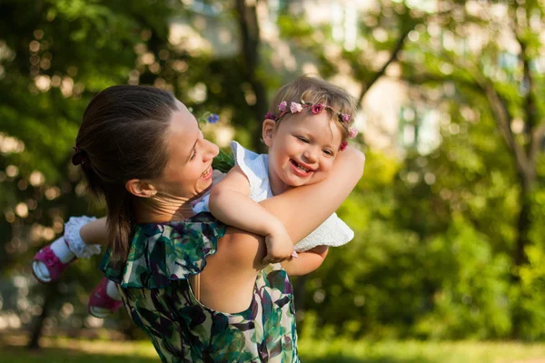 Lachende moeder en haar dochter in zomer park. — Stockfoto