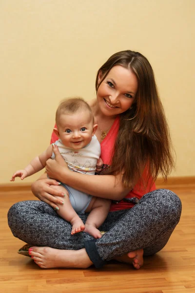 Junge Mutter spielt mit ihrem Sohn zu Hause. — Stockfoto