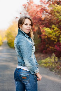genç kadın sonbahar yolunda kot pantolon