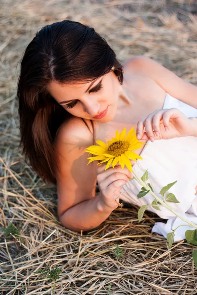 Güzel bir kız ile ayçiçeği saman içinde. — Stok fotoğraf