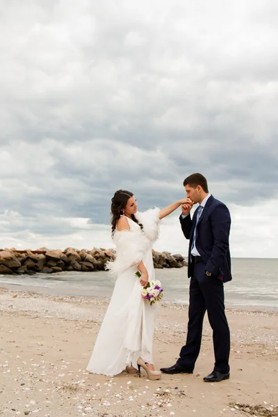 Happy newlyweds are walking near the seashore — Stock Photo, Image