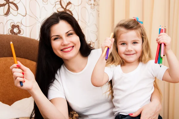 Schattig klein meisje met haar moeder voor tekening. — Stockfoto