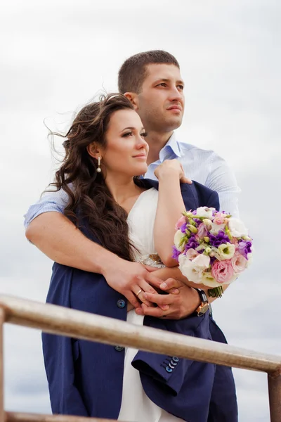 Loving bride and groom standing on the pier — Stock Photo, Image