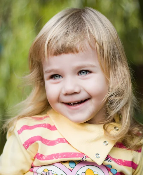 Маленькая эмоциональная девочка в парке — стоковое фото