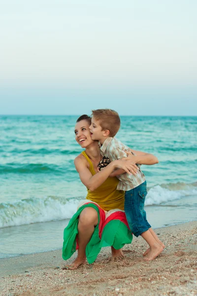 Jonge moeder met haar zoon plezier op het strand — Stockfoto