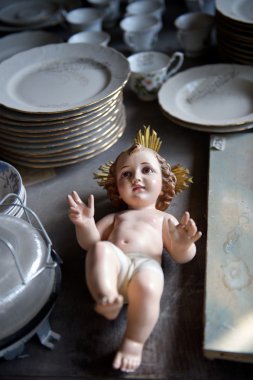 Baby Jesus statuette relegated to an antiques shop clipart