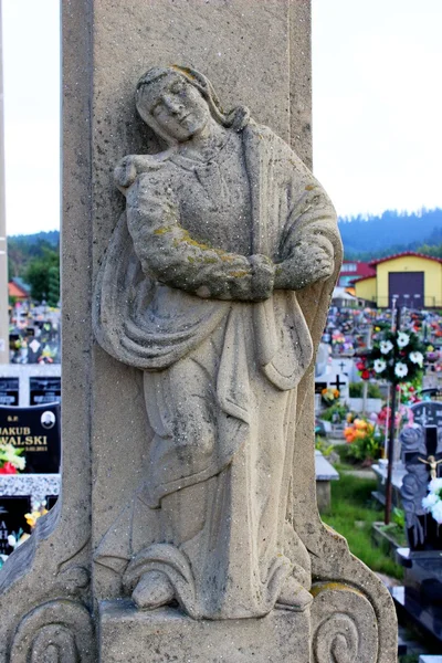 Vintage-Statue einer jungen Jungfrau, die mit einem Rosenkranz betet, der an ihren Armen vor einem felsigen Hintergrund hängt — Stockfoto