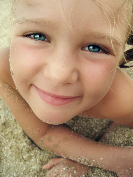 Retrato de cerca de una niña sonriente en la playa — Foto de Stock