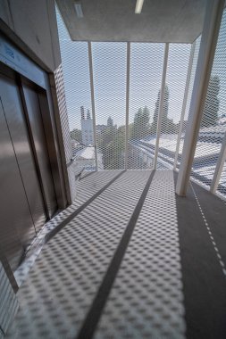 Bu yeni merdiven yenilenmiş bir binanın yanına eklendi, merdiven bir asansörün etrafında dönüyor.