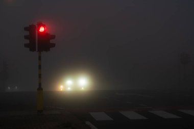 Sabahın köründe yoğun siste trafik ışıkları var.