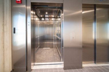 Büyük bir binanın koridorunda bir asansör var.