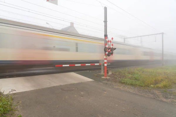 Туманное Утро Этом Переходе Пути Барьером Огнями Пассажирский Поезд Бушует — стоковое фото