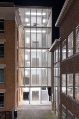 Bu yeni merdiven yenilenmiş bir binanın yanına eklendi, merdiven bir asansörün etrafında dönüyor.